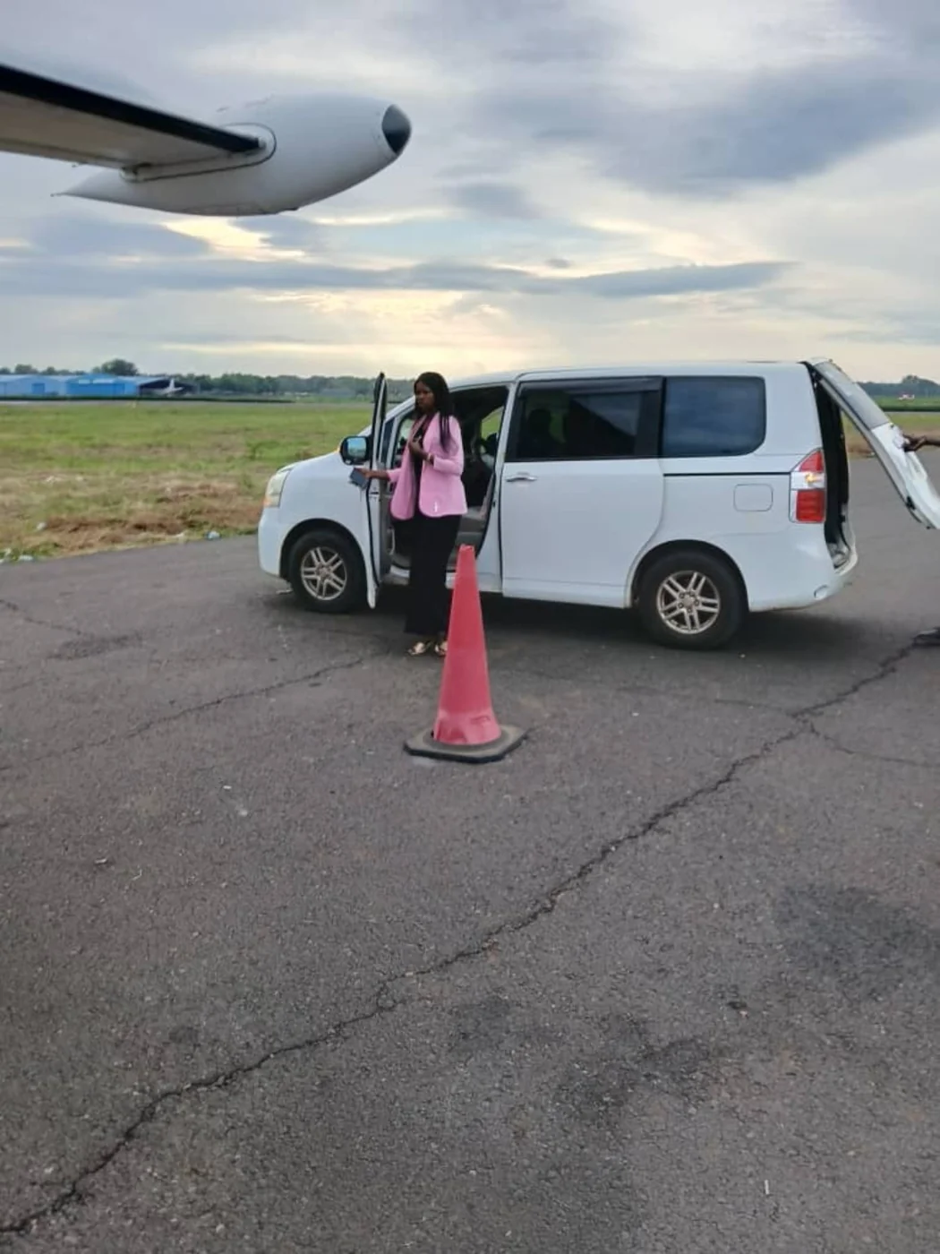 A white vehicle positioned near an aircraft on the airside